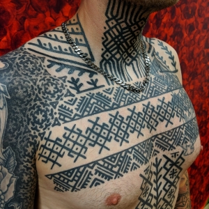 bold ornamental bodysuit chestpiece tattoo